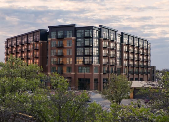 an image of a large apartment building with trees in the foreground