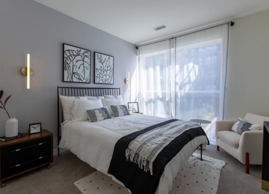 Maple Street Lofts - Bedroom with Two-Toned Paint, Bed, Dresser, Chair, Nightstand, and Window.