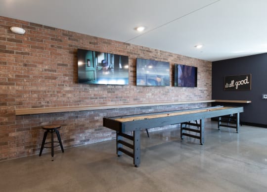 a game room with a shuffleboard table and a bar