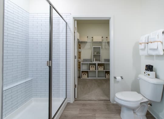 a bathroom with a white toilet and a shower with a glass door