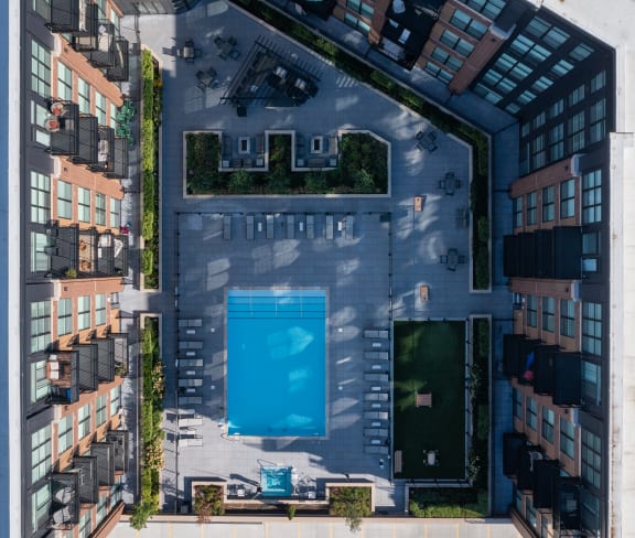 an aerial view of a building with a blue pool in the middle of it