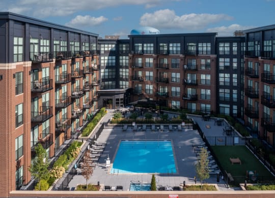 an aerial view of a large pool in front of a building