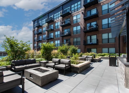 an outdoor patio with a firepit and seating