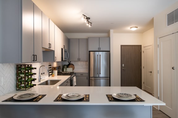 a kitchen with white countertops and stainless steel appliances