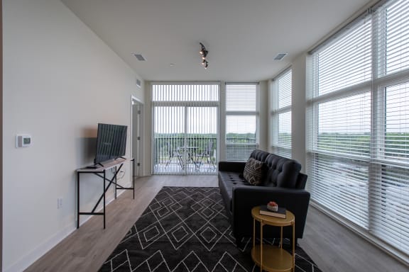 a living room with a black couch and a tv on a stand