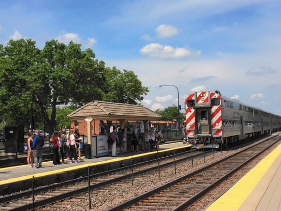 people are waiting to board a train at a train station